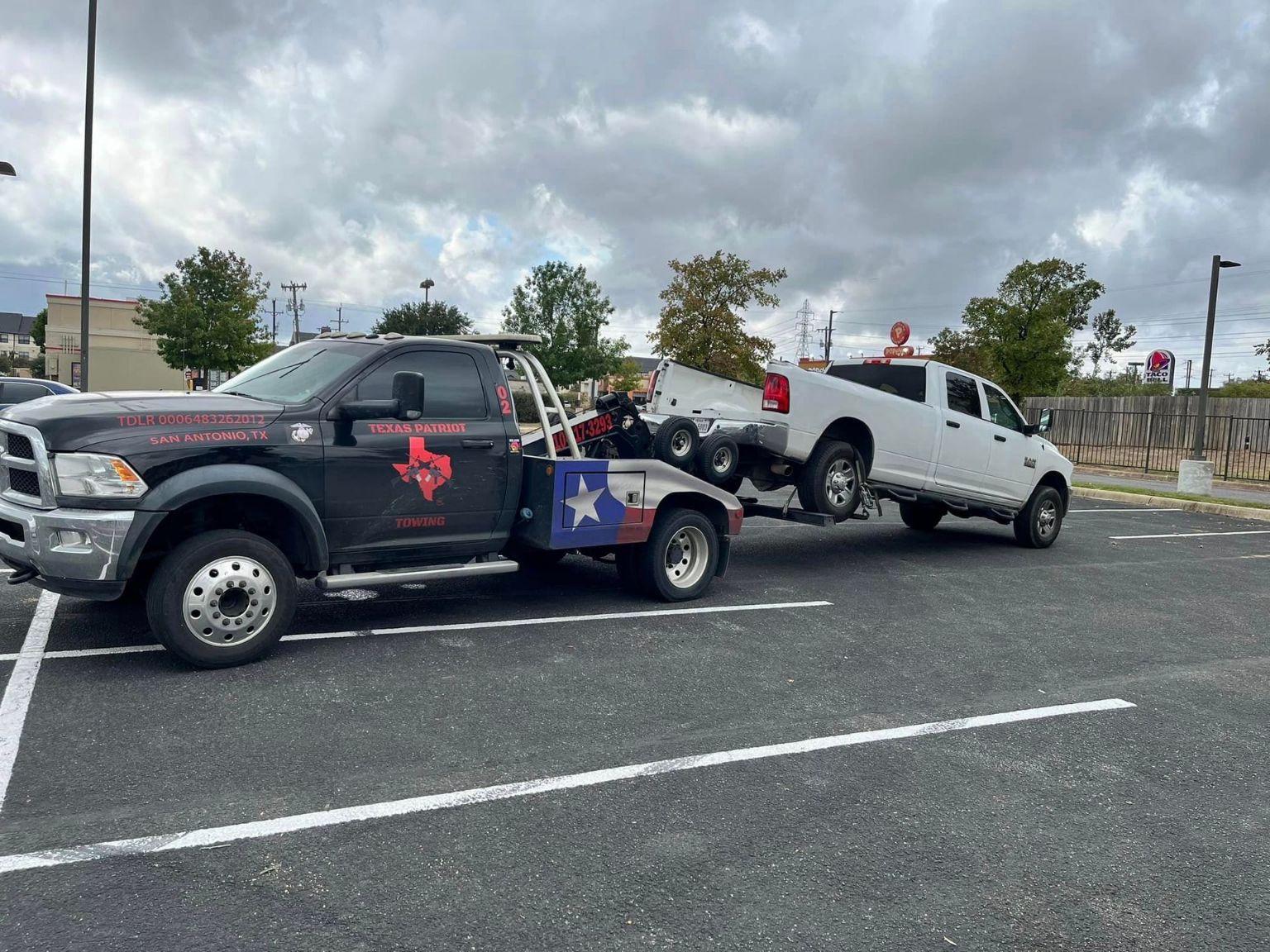 a texas tow truck is towing a white truck
