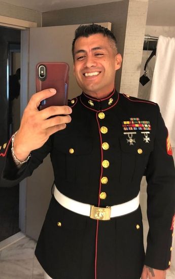 a man in a military uniform takes a selfie with his phone