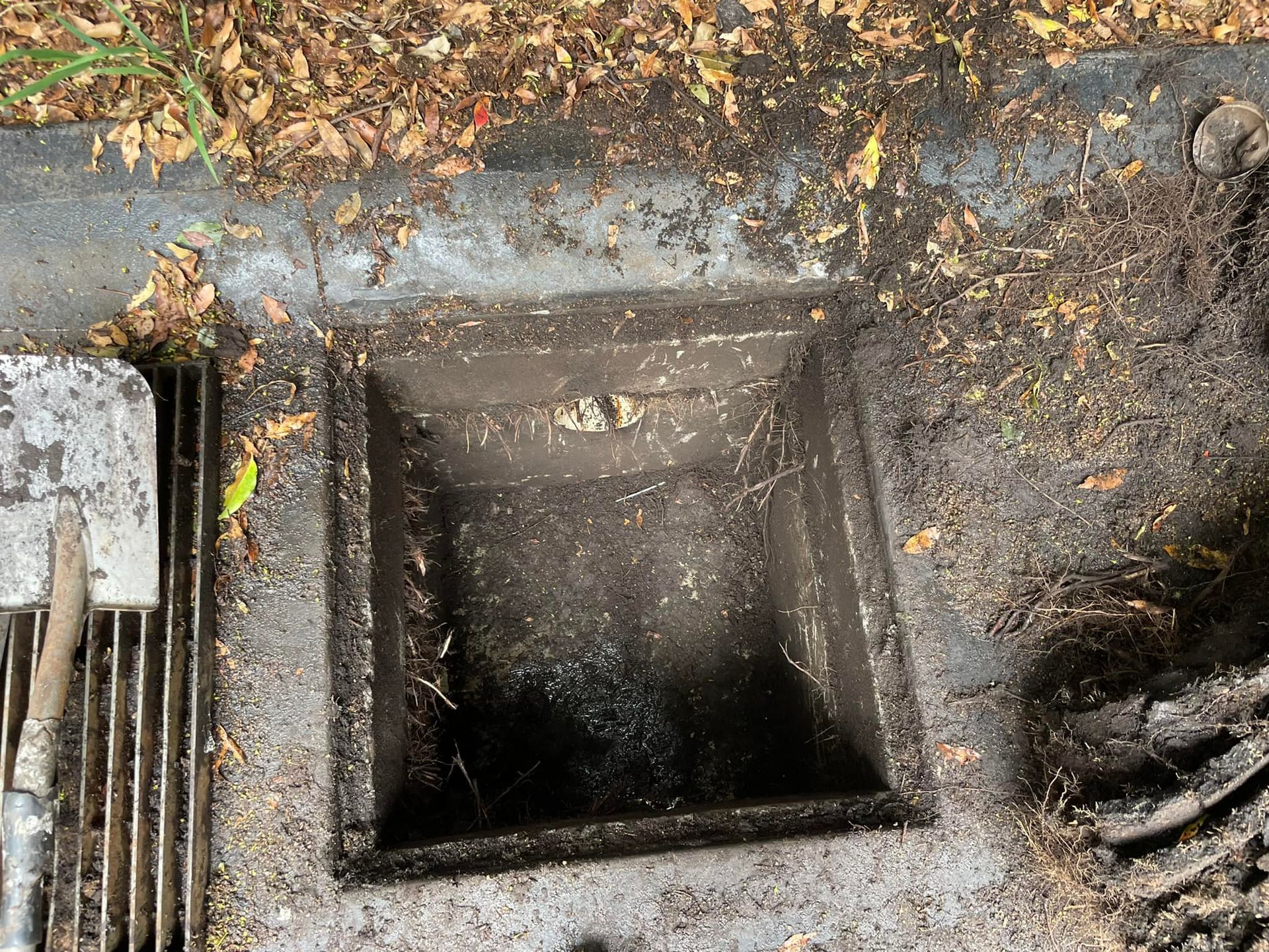 Open Square Sewer Drain in the Ground, Surrounded by Debris — All Stars Plumbing In Shellharbour, NSW