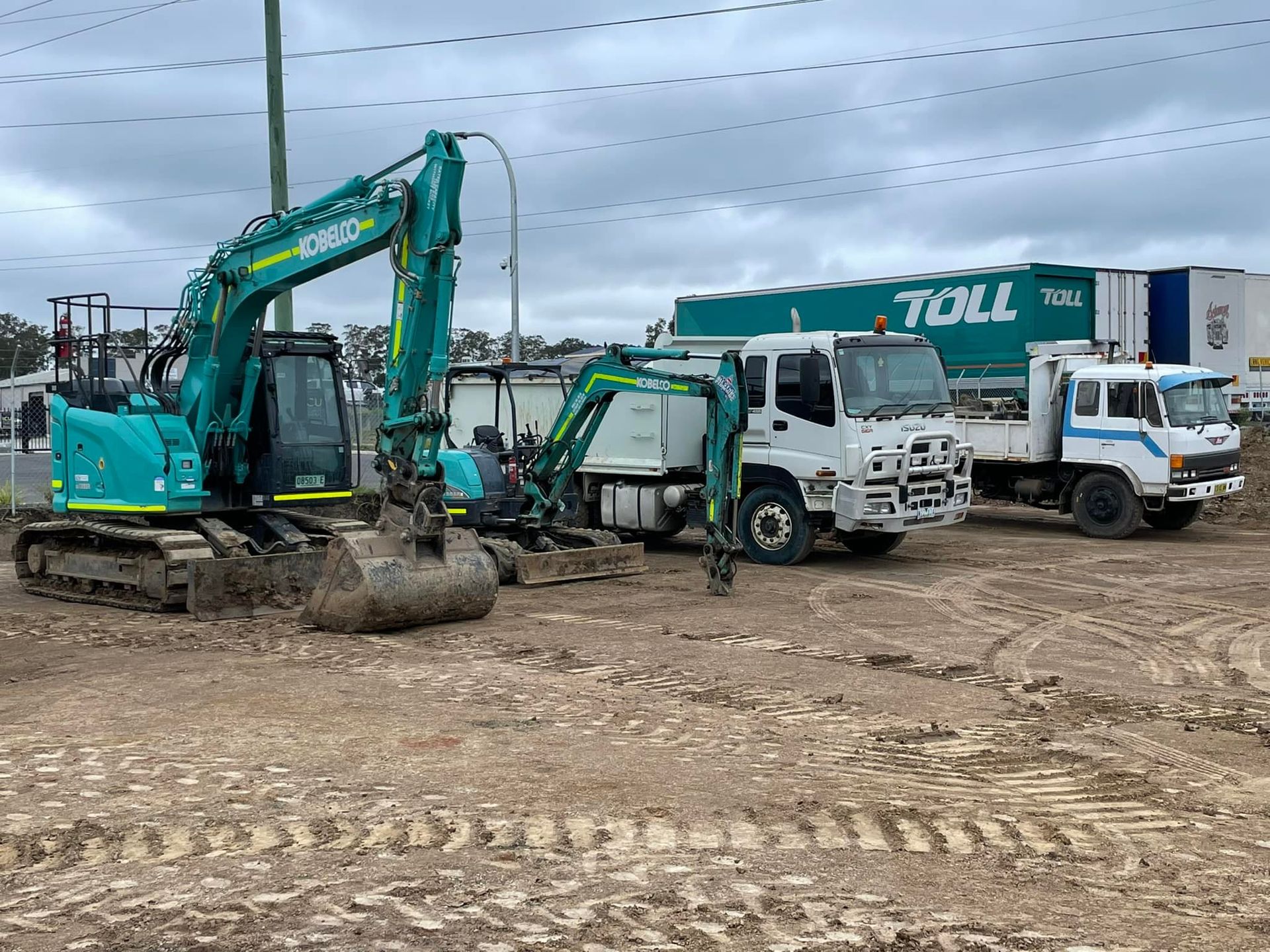 Construction site with excavator and trucks on muddy ground. — All Stars Plumbing In Barrack Heights, NSW