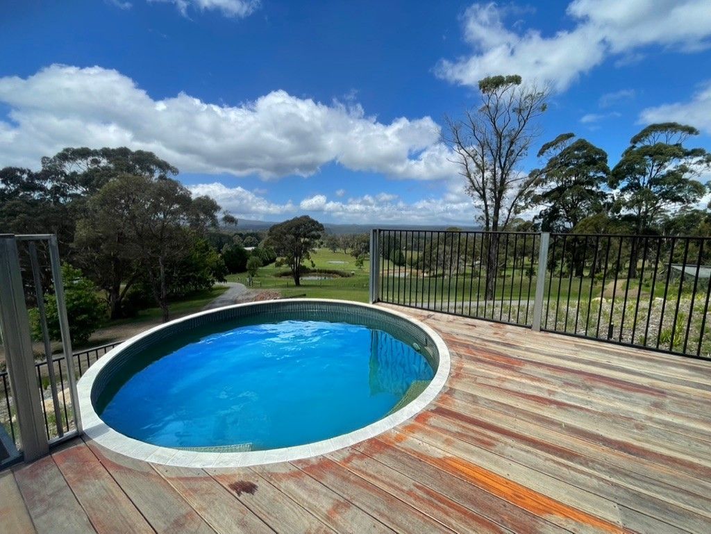 Oval pool on a wooden deck overlooking a green field and trees under a blue sky. — All Stars Plumbing In Dapto, NSW