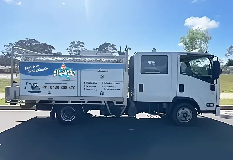 White Isuzu truck with logo on the side, parked on a street. Blue sky in background. — All Stars Plumbing In Barrack Heights, NSW