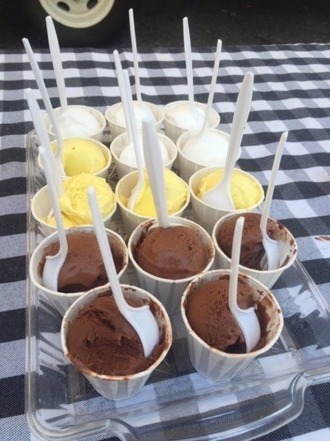 A tray of ice cream cups with spoons in them