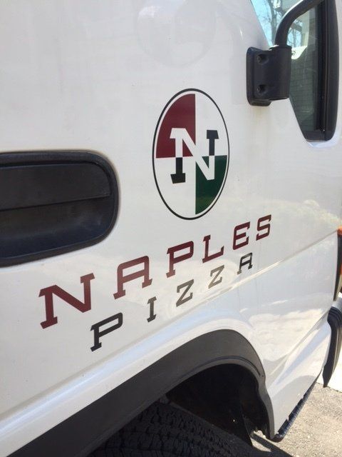 A white van with naples pizza written on the side