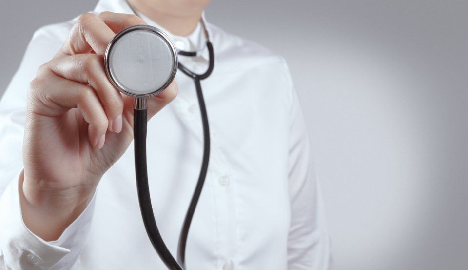 Doctor holding a stethoscope against a white coat