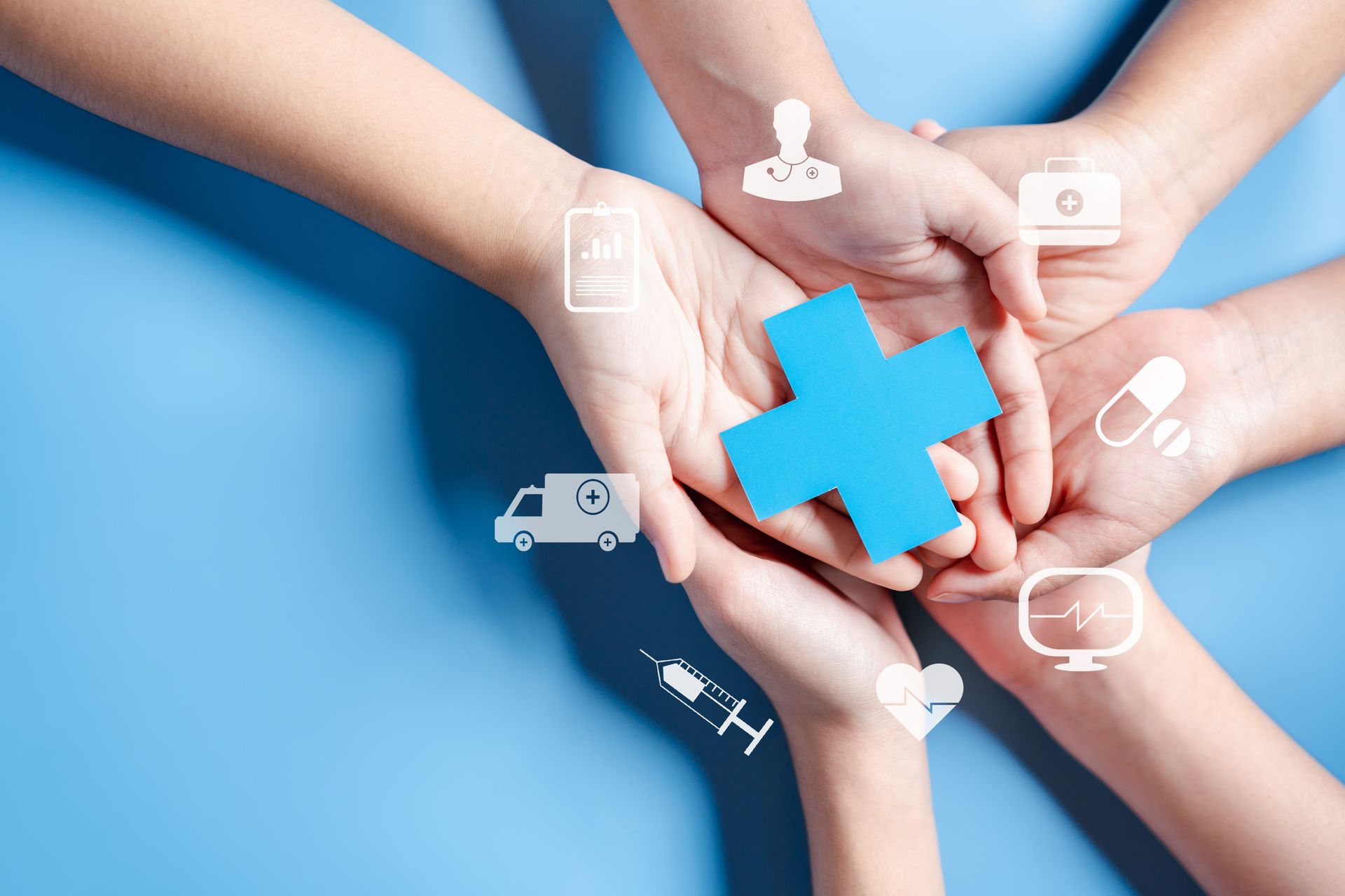 Hands holding a blue medical cross with healthcare icons on a blue background