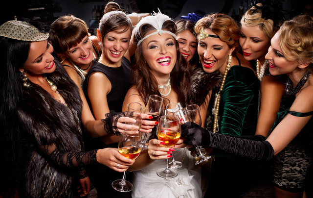A group of women are standing around a bride holding wine glasses.