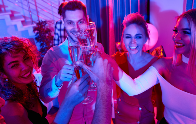 A group of people are toasting with champagne glasses at a party.