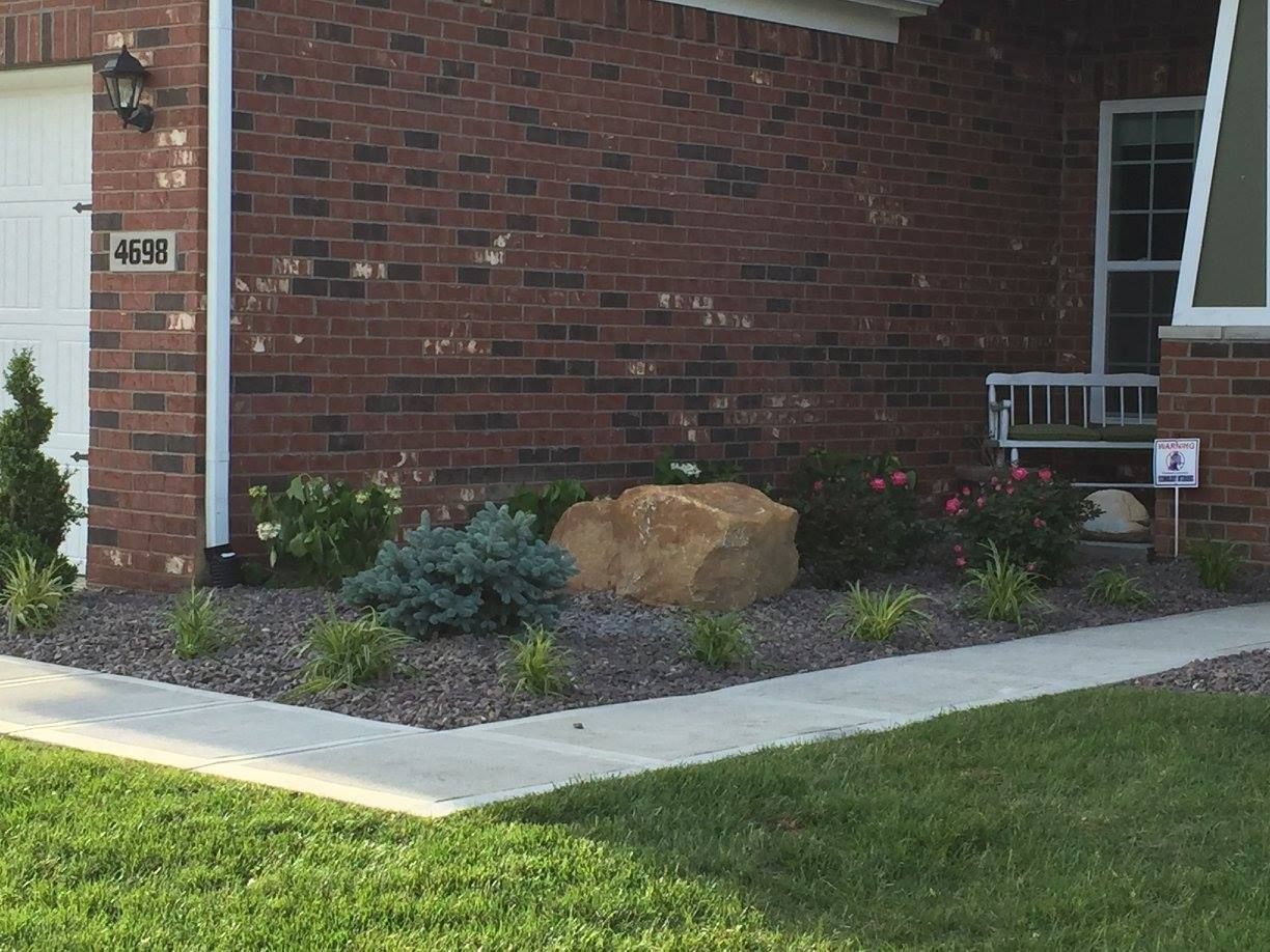 A brick house with a rock in front of it