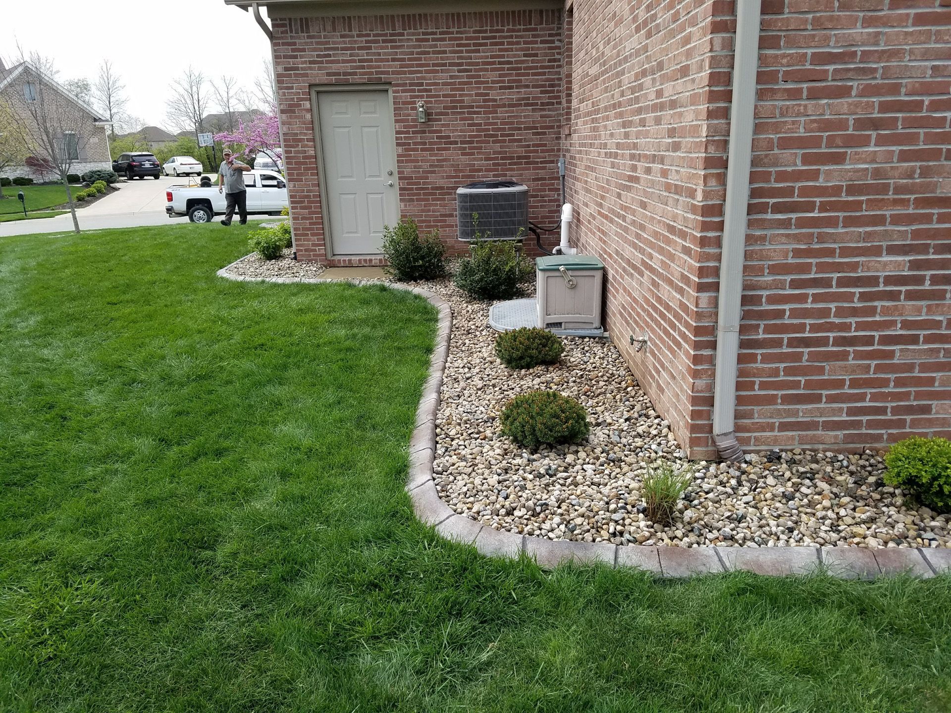 A brick house with a lush green lawn in front of it.