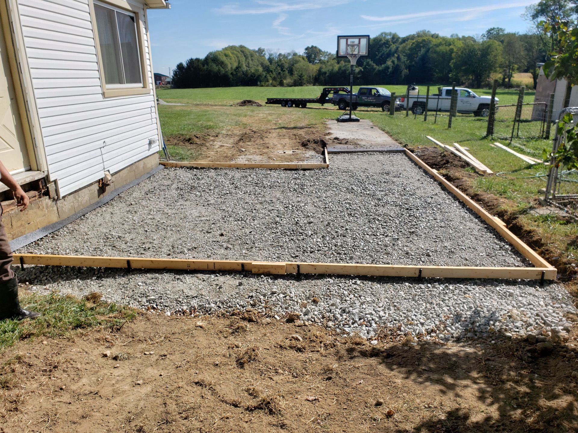 A basketball hoop is being built in the backyard of a house.