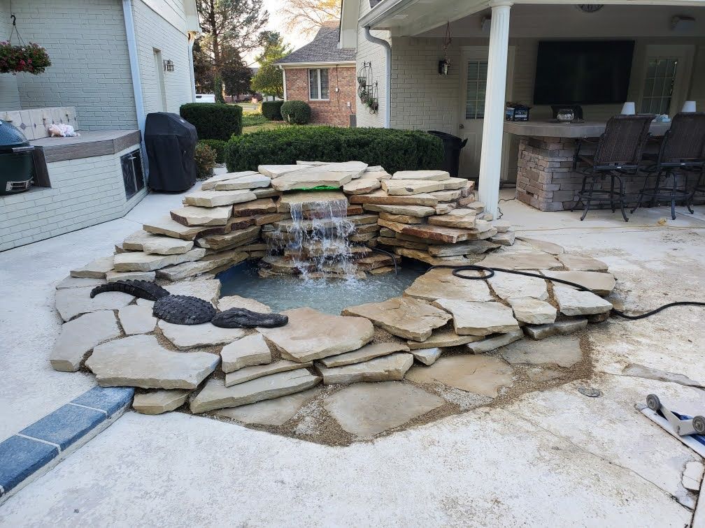 A waterfall is being built in the backyard of a house.