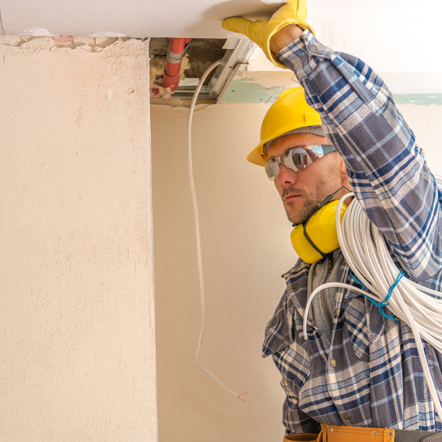 House under construction with exposed brickwork, steel beam, and concrete blocks.