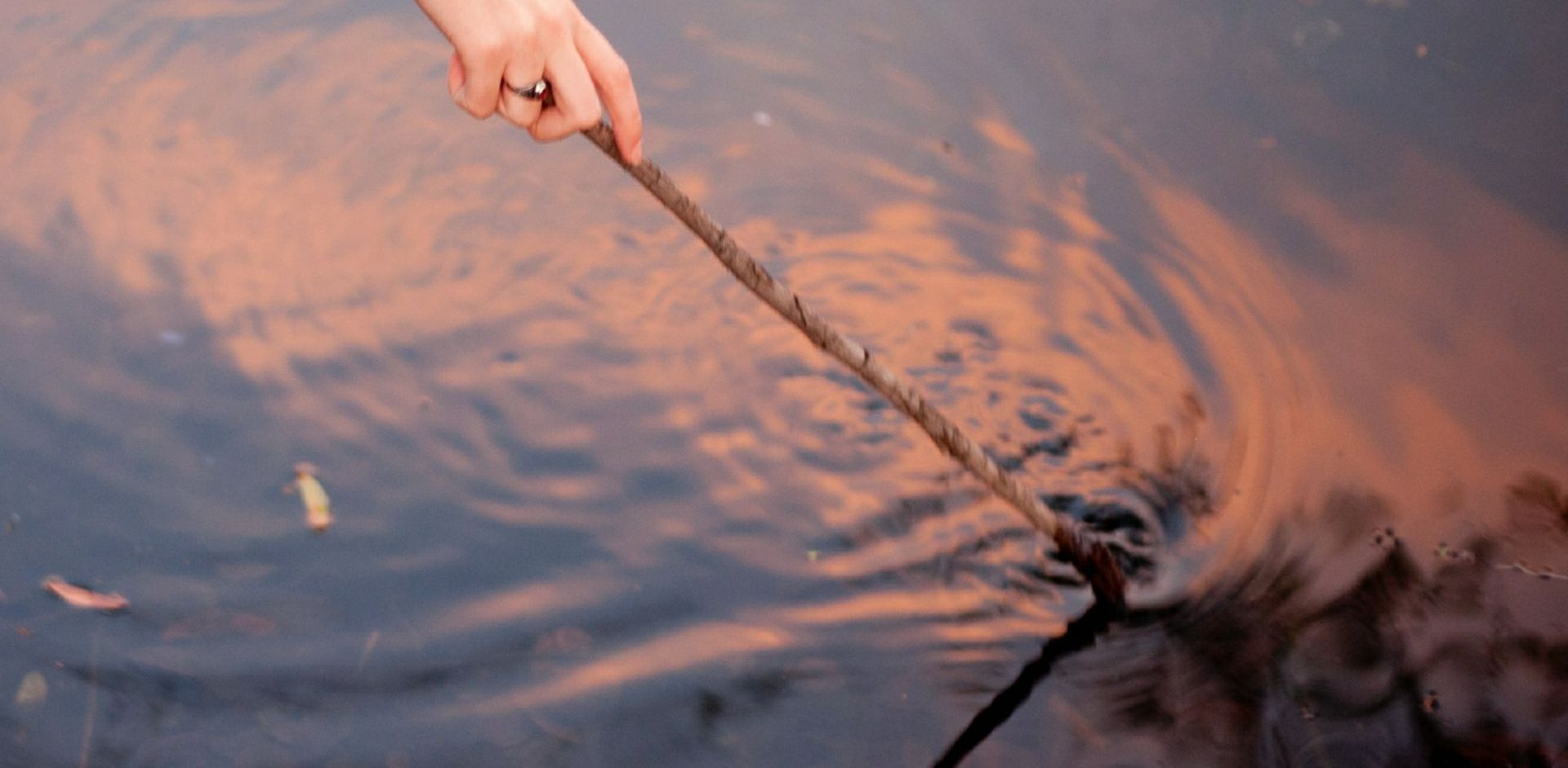 pulling a stick through a pool of water