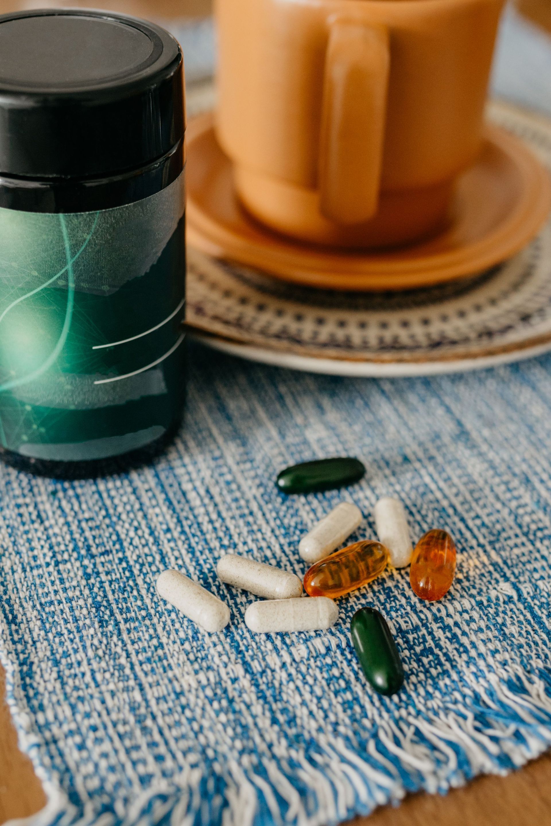 Pastillas y suplementos variados junto a un frasco de vitaminas