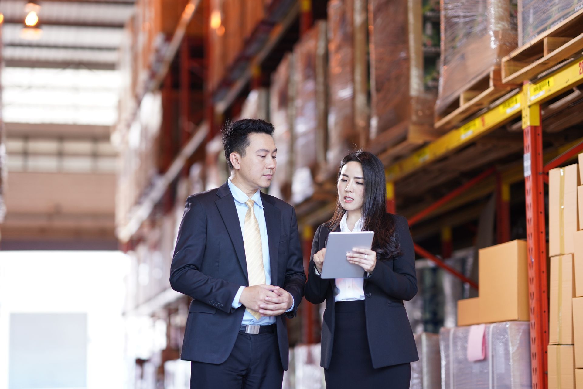 Two people are sitting at a table using a laptop computer.