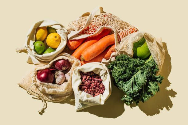 A bunch of bags filled with fruits and vegetables on a table.