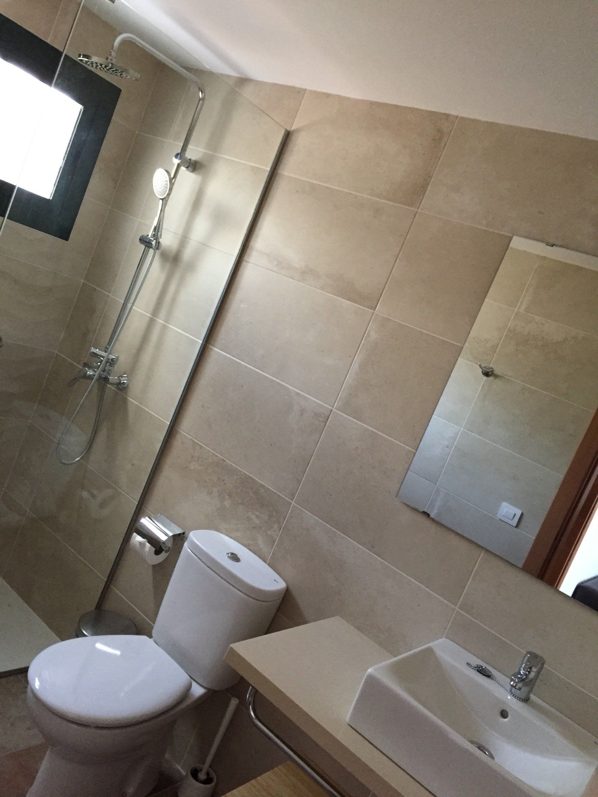 Bathroom with sink shelf, shower, hear dryer and gel soap dispenser in the Villa Canaima Apartments