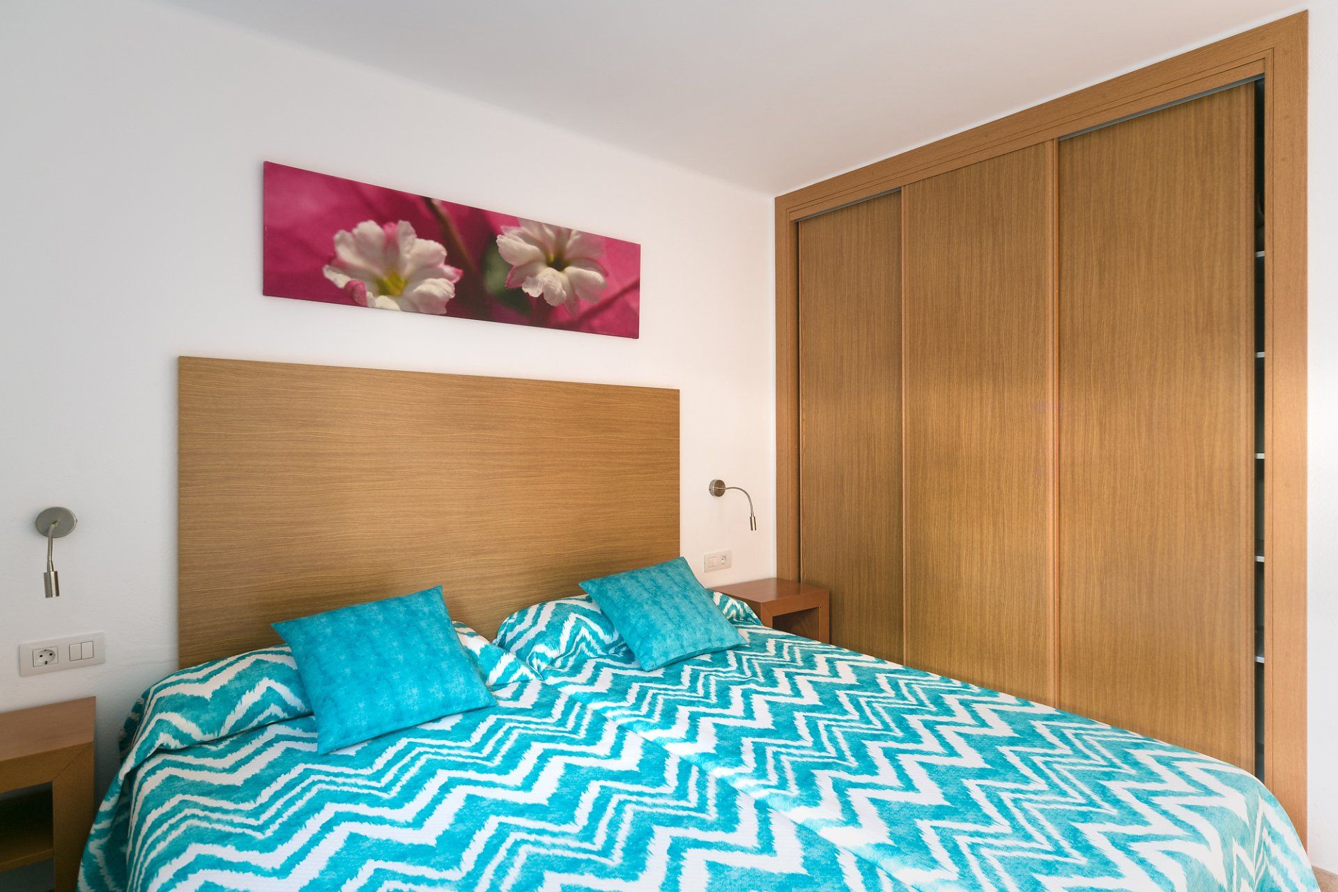 A Bedroom with 2 beds 1x2 meters each, wardrobe, bedside tables, and reading lamps in Villa Canaima Apartments