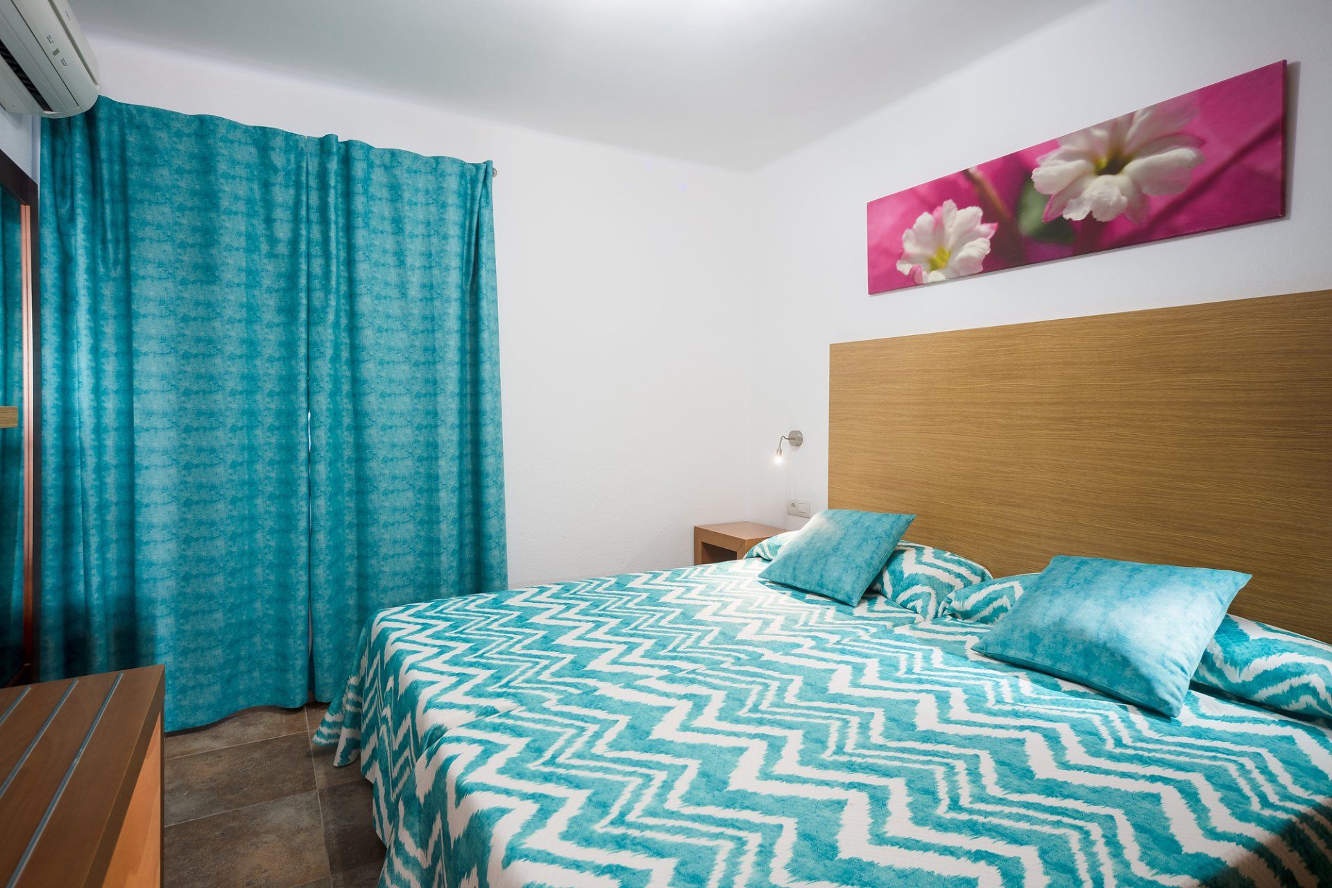 A Bedroom with air conditioning, two 1x2 meter beds, and luggage rack in Villa Canaima Apartments