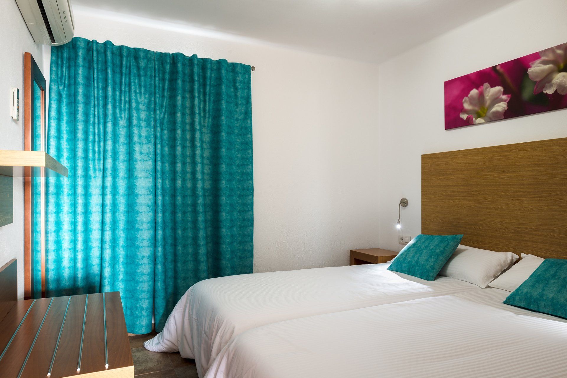 A Bedroom with air conditioning, two 1x2 meter beds, and luggage rack in Villa Canaima Apartments