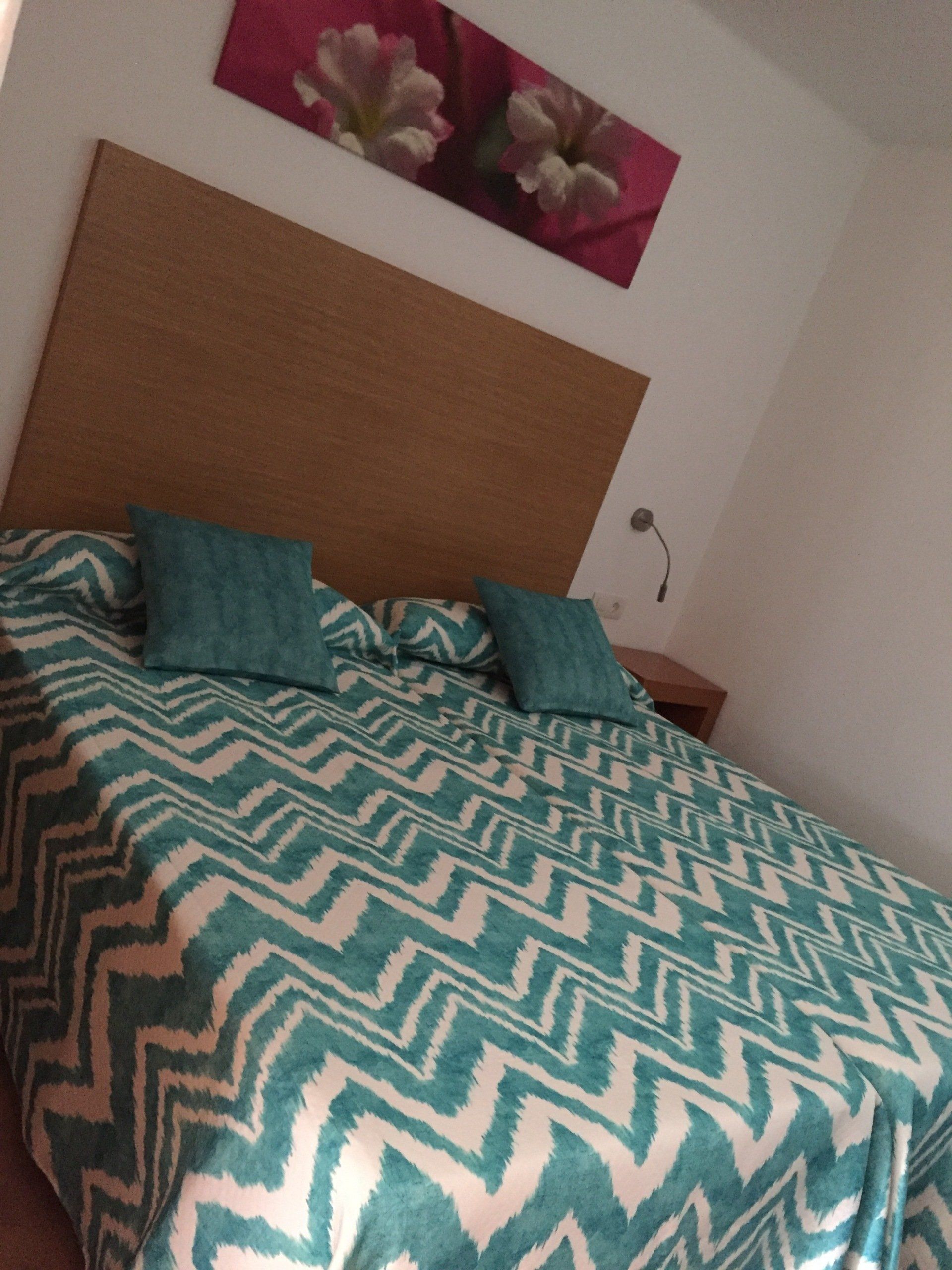 A Bedroom with 2 single beds measuring 1x2 meters, bedside tables, and reading lamps in Villa Canaima Apartments
