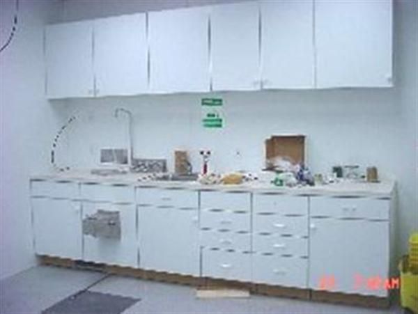 A kitchen with white cabinets and drawers and a sink.