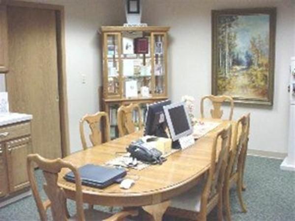 A room with a table and chairs with computers on it