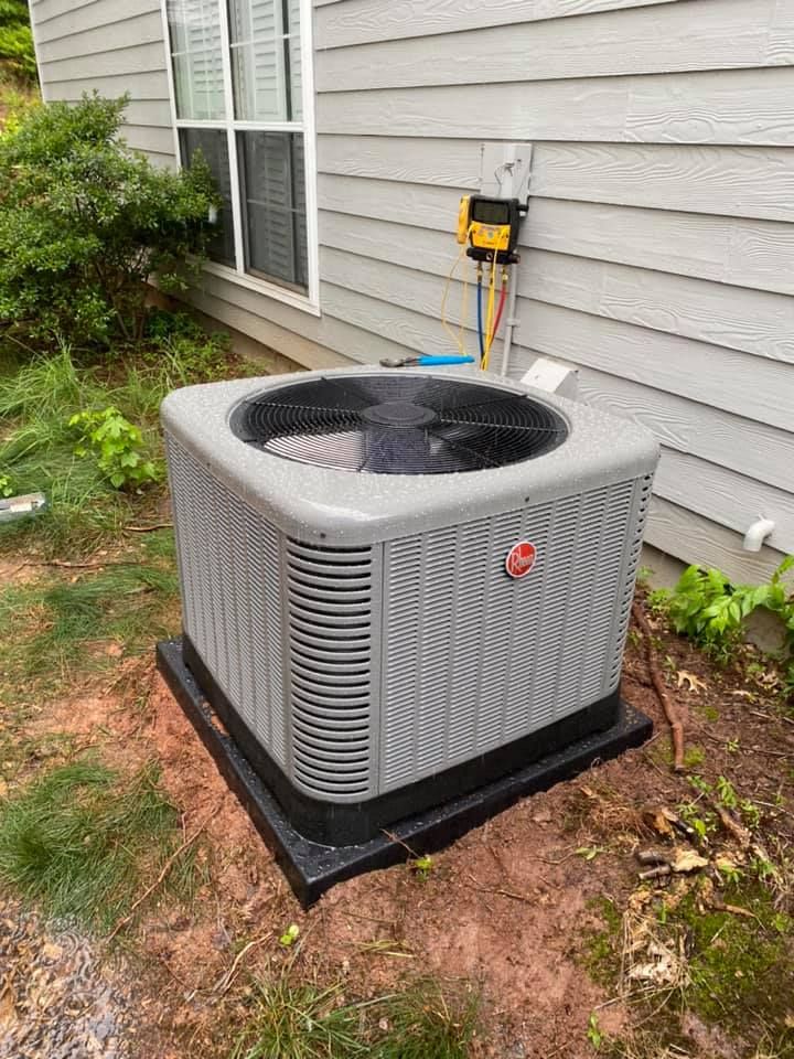 An air conditioner is sitting on the side of a house.