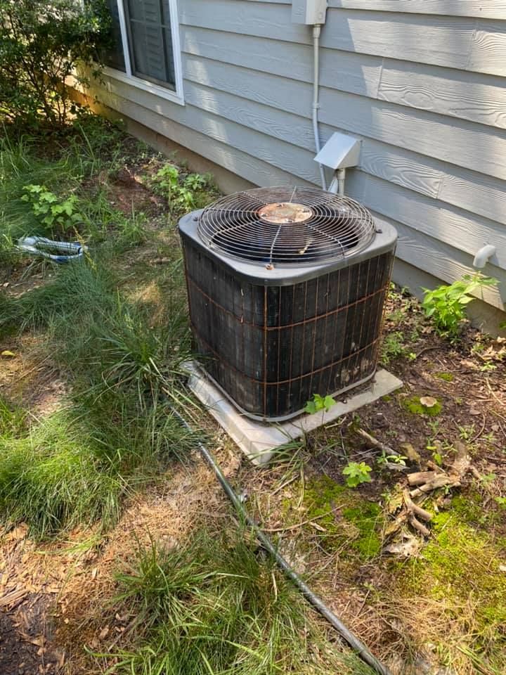 An air conditioner is sitting on the side of a house.