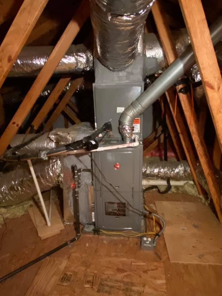 An air conditioner is in the attic of a house