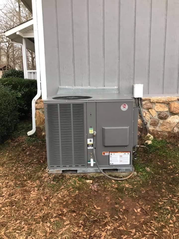 An air conditioner is sitting on the side of a house.