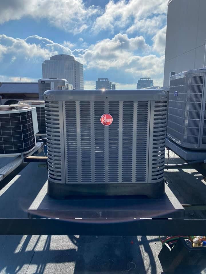 A large air conditioner is sitting on top of a roof.