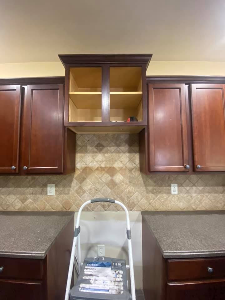 A kitchen with a ladder in the middle of it