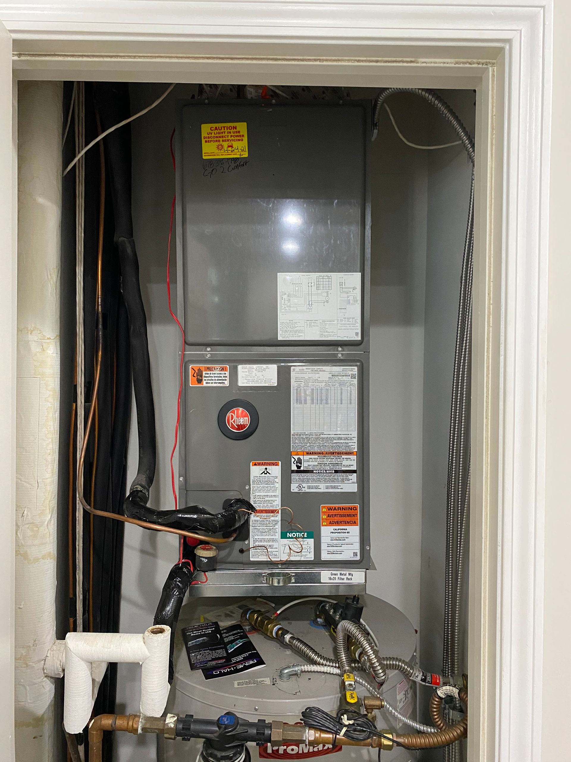 An air conditioner is sitting inside of a doorway in a room.