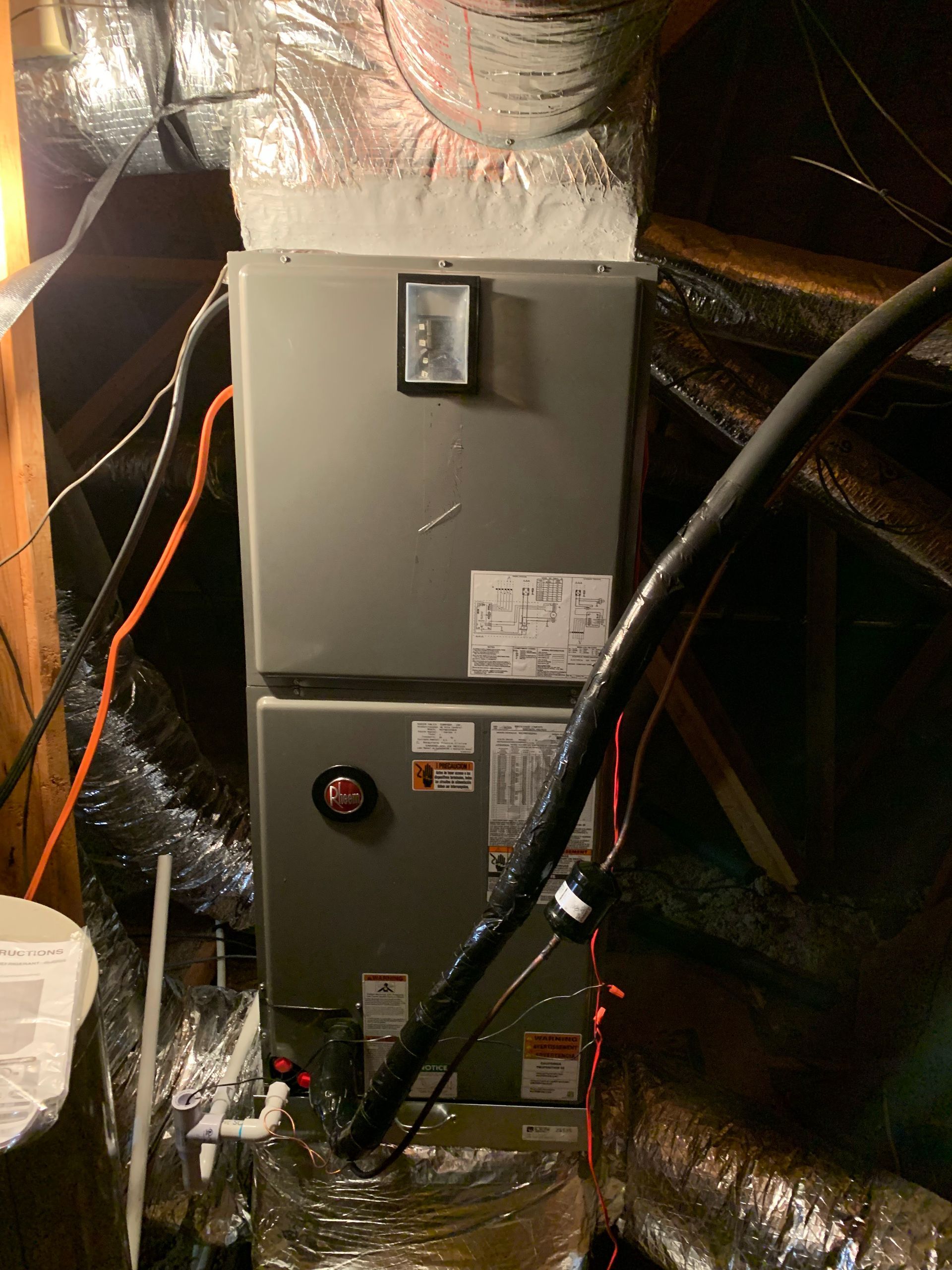 An air conditioner is sitting in the attic of a house.