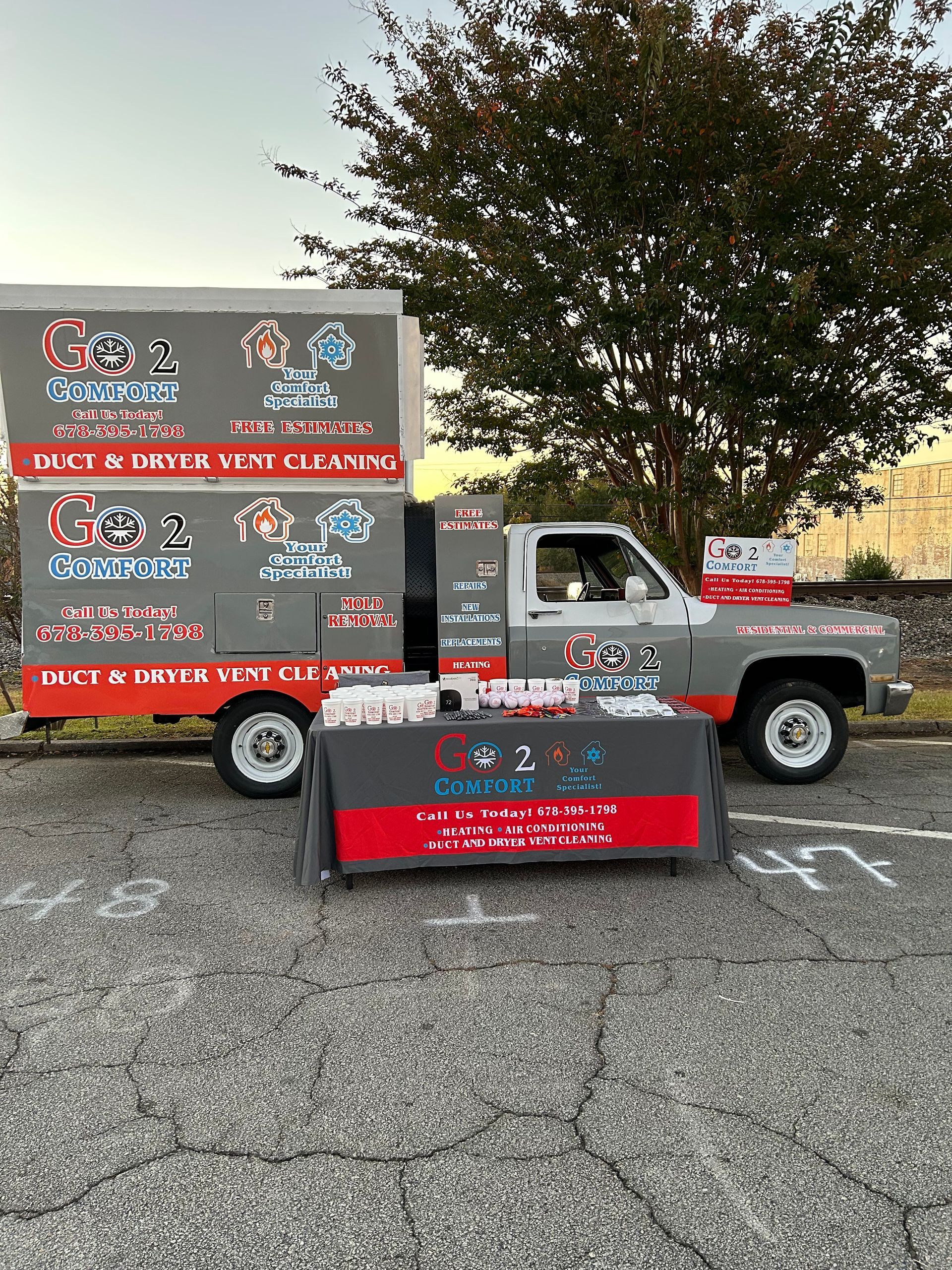 A truck is parked in a parking lot next to a table.