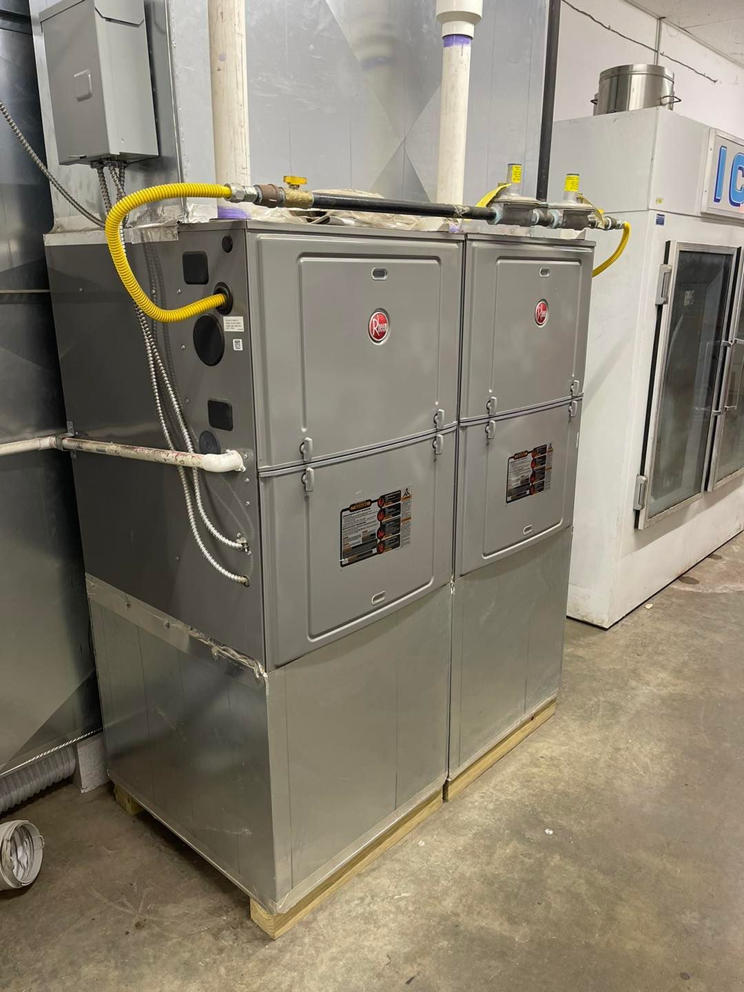 Two stainless steel furnaces are sitting next to each other in a room.