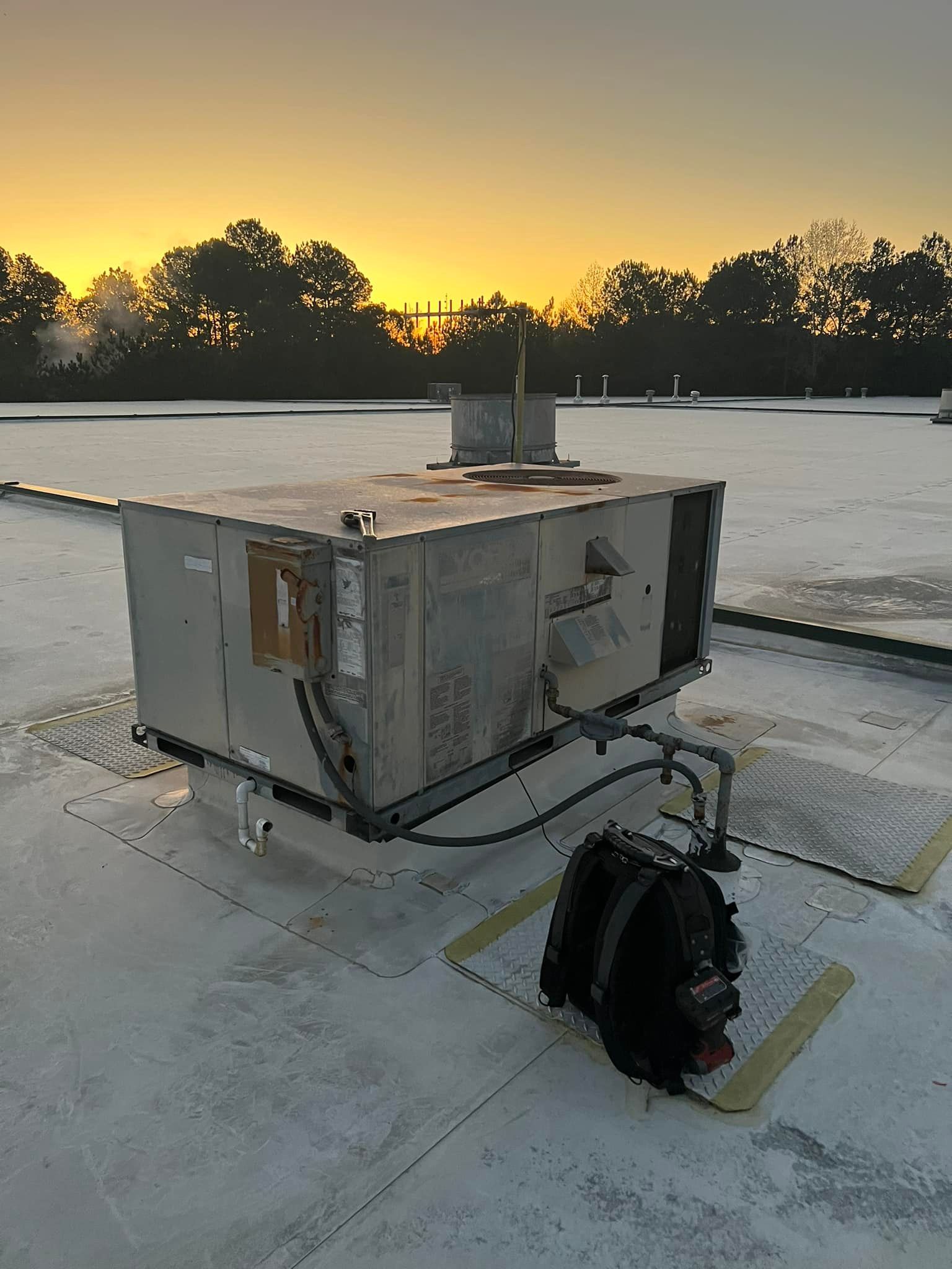 A large box is sitting on top of a roof at sunset.
