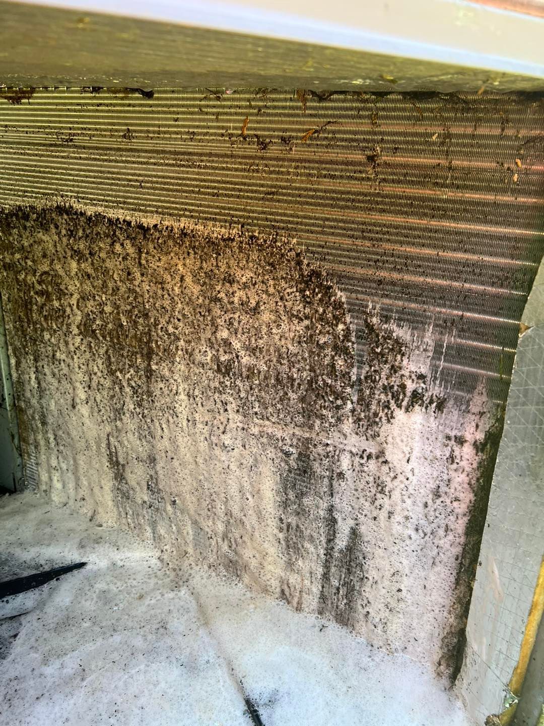 A close up of a dirty air conditioner coil.