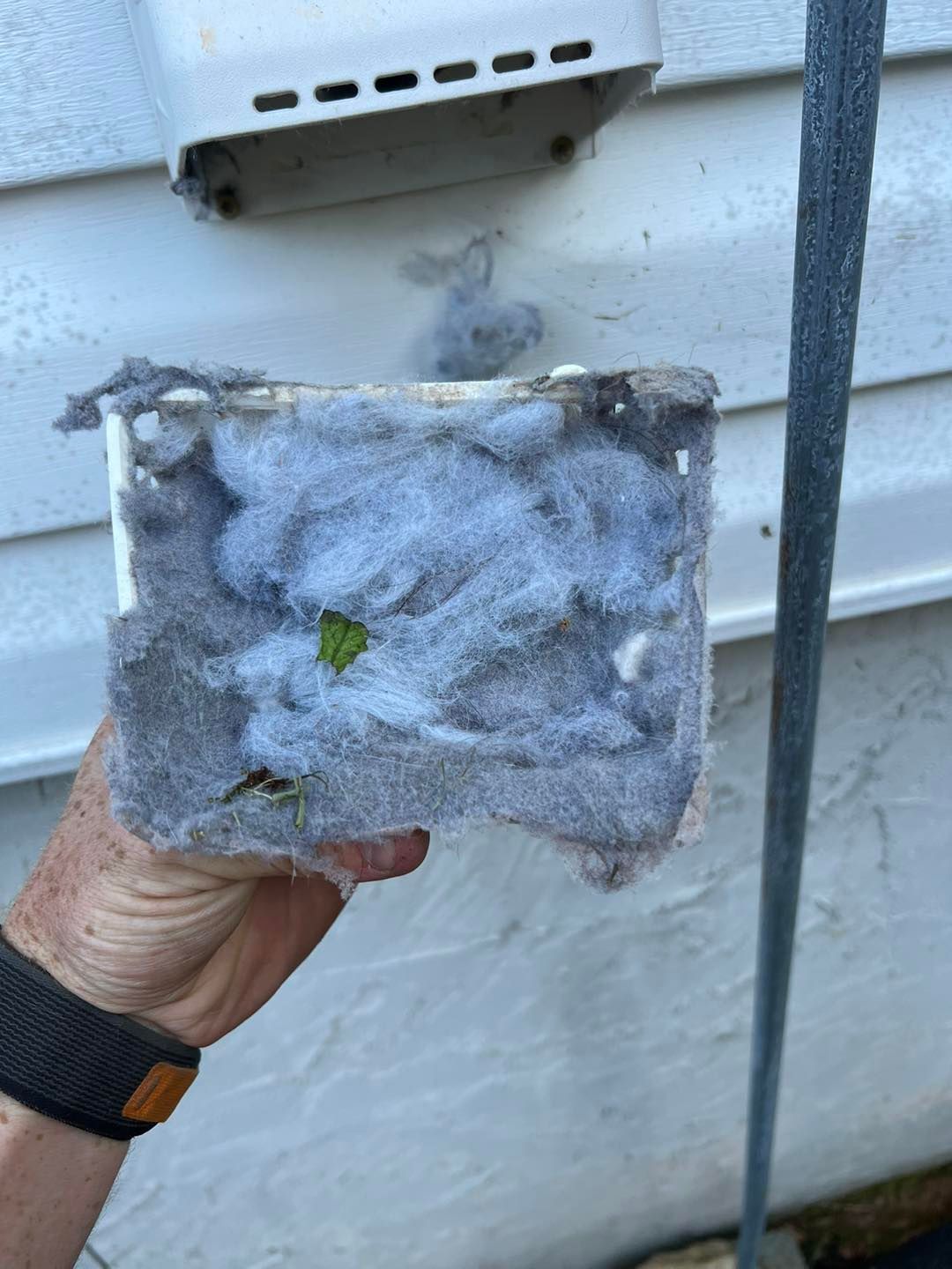 A person is holding a piece of dust filter in their hand.