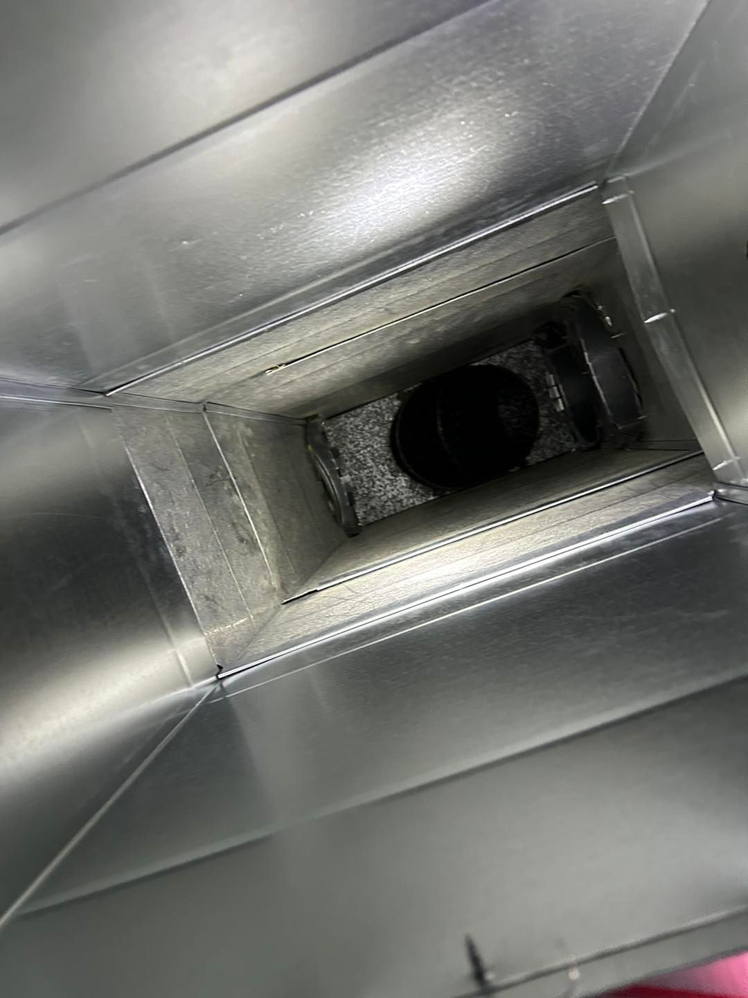 A close up of a metal duct with a hole in the middle.