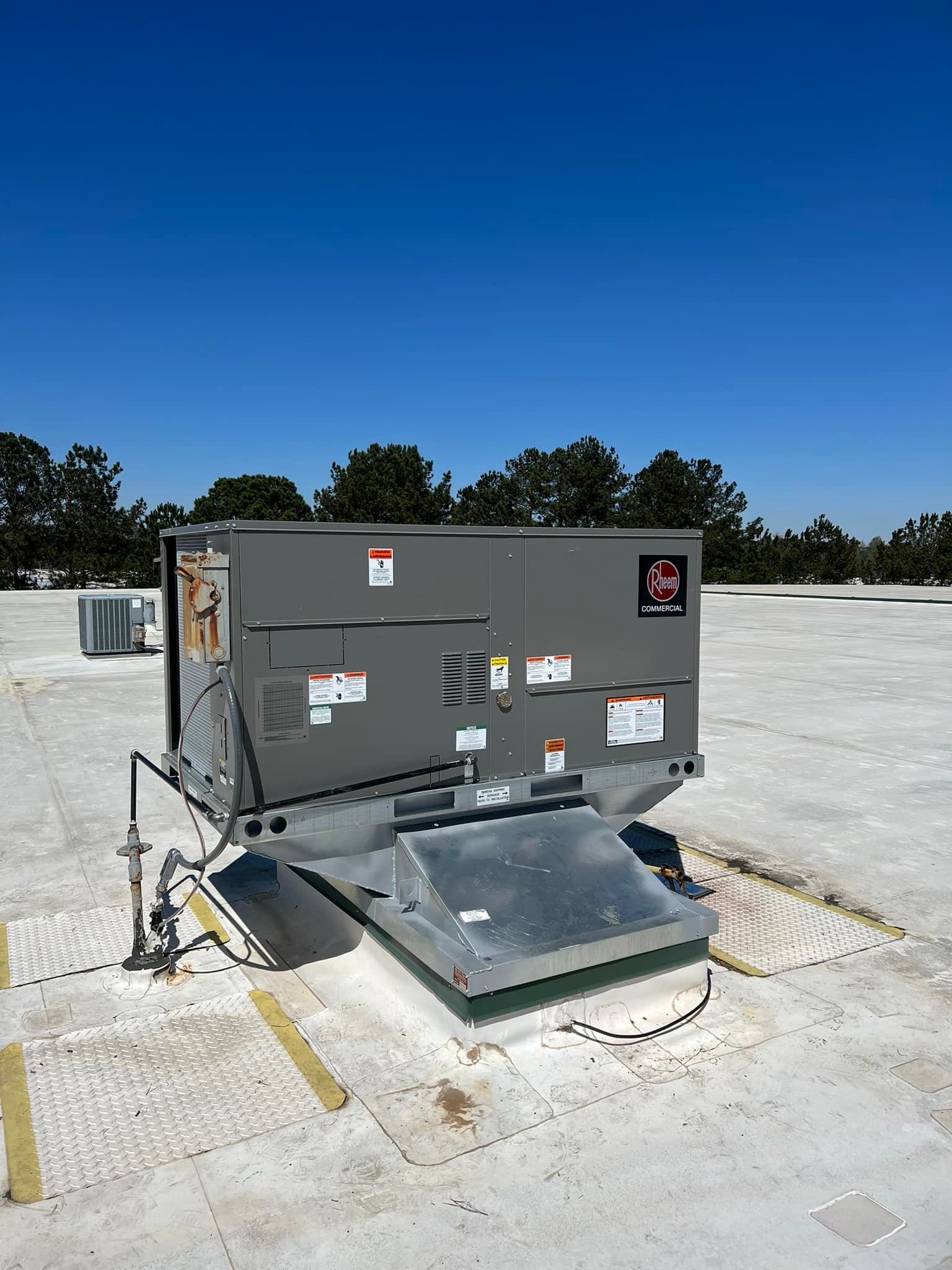 A large air conditioner is sitting on top of a roof.