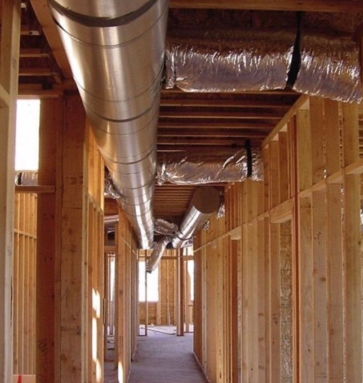 A hallway with a lot of pipes going through it