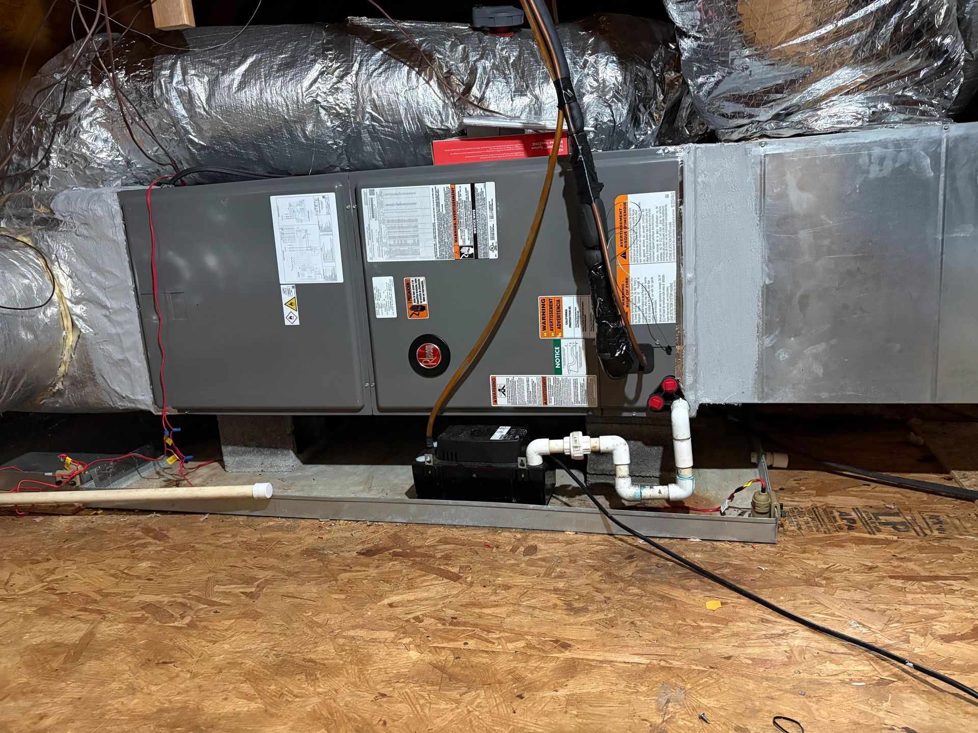 HVAC furnace and ductwork in a crawlspace with exposed insulation and pipes