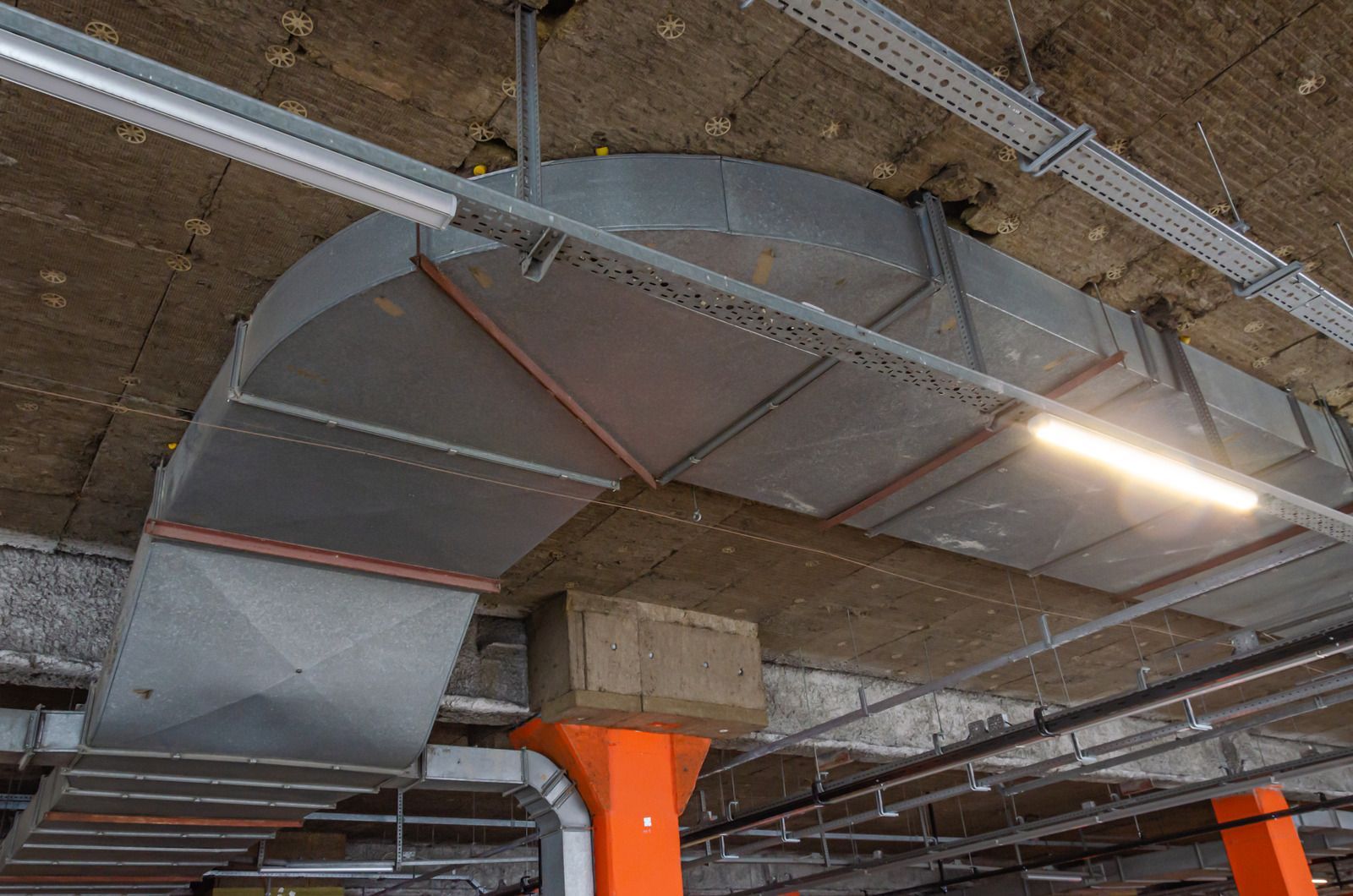 A large metal pipe is hanging from the ceiling of a building.