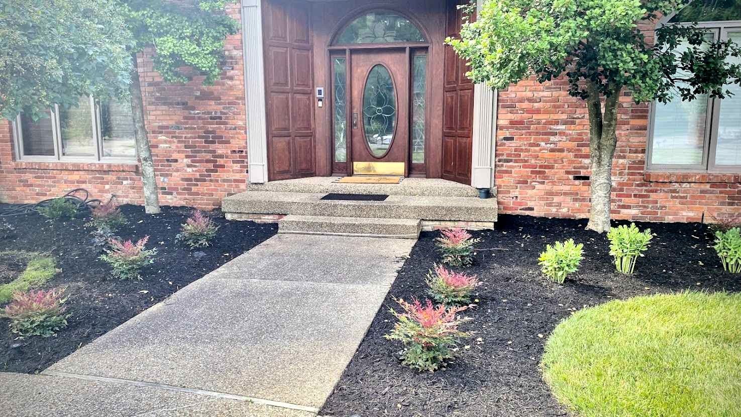 A brick house with a walkway leading to the front door.