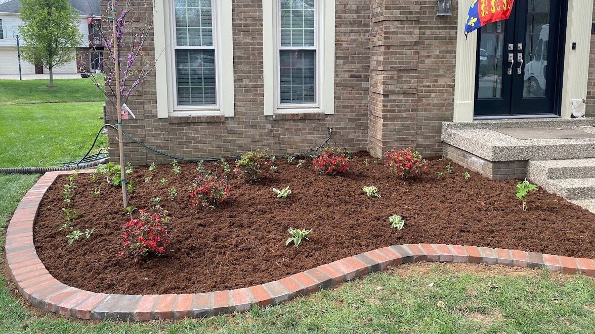 A brick house with a garden in front of it.