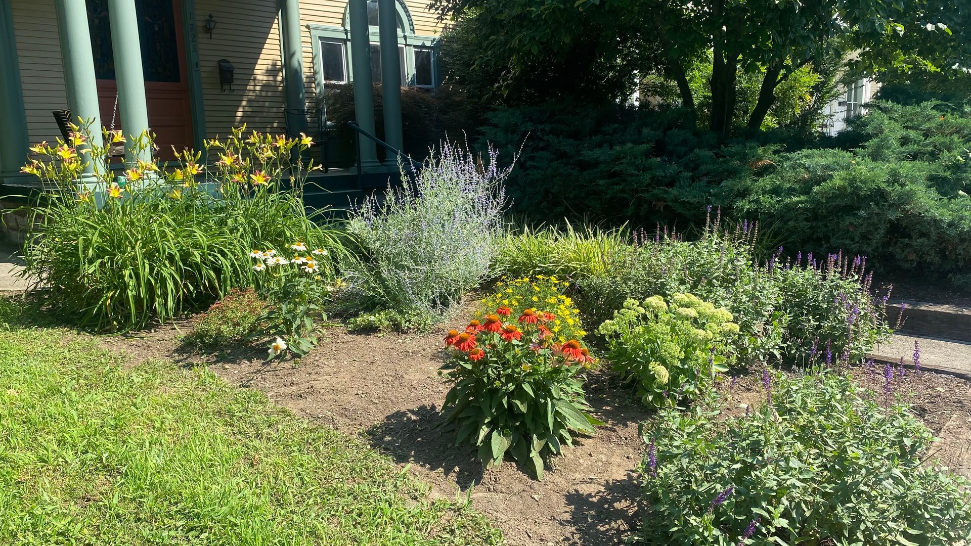 There is a brick walkway in the middle of the garden.