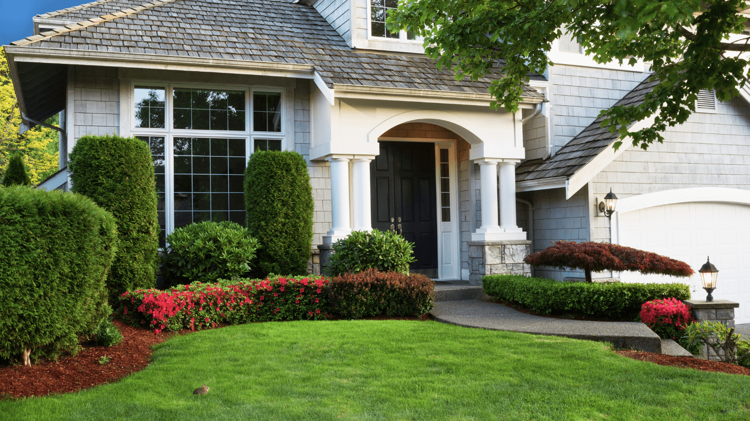 A large house with a lush green lawn in front of it.